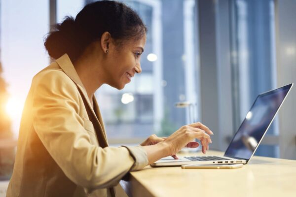 Business woman using a laptop to view website imagery on her website