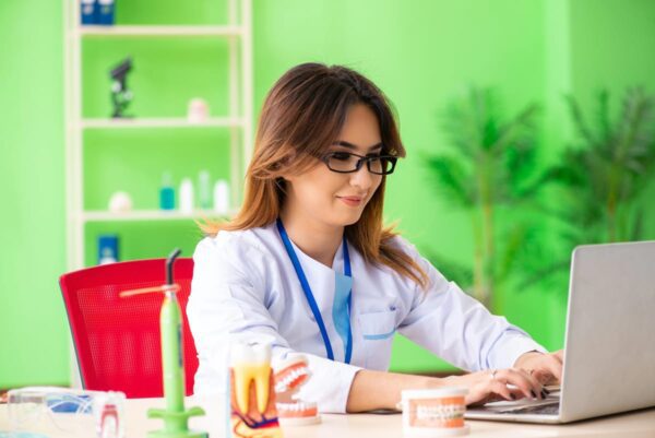 A woman using a laptop planning local SEO for dentists